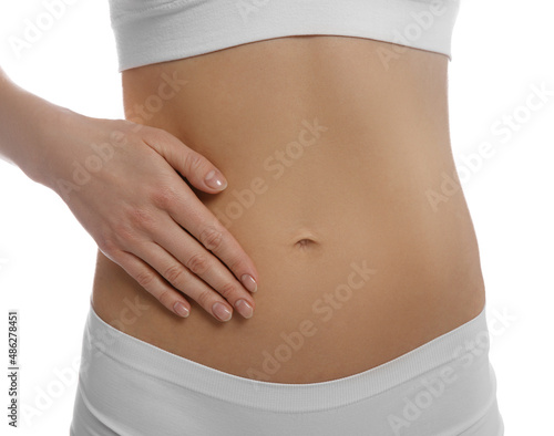 Woman holding hand on belly against white background, closeup