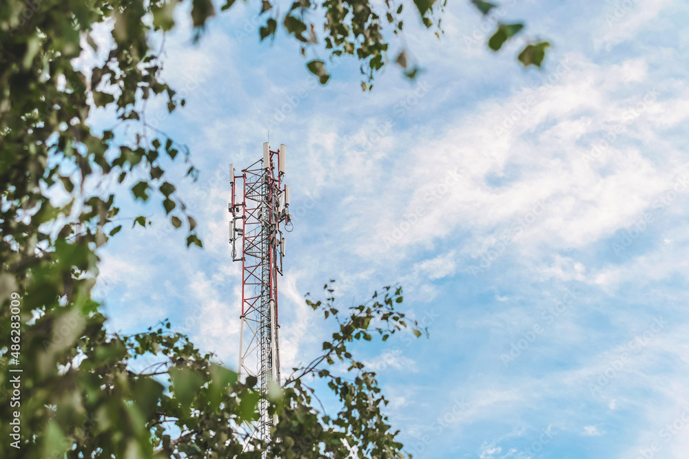 Obraz premium Cell tower against a blue sky with clouds.