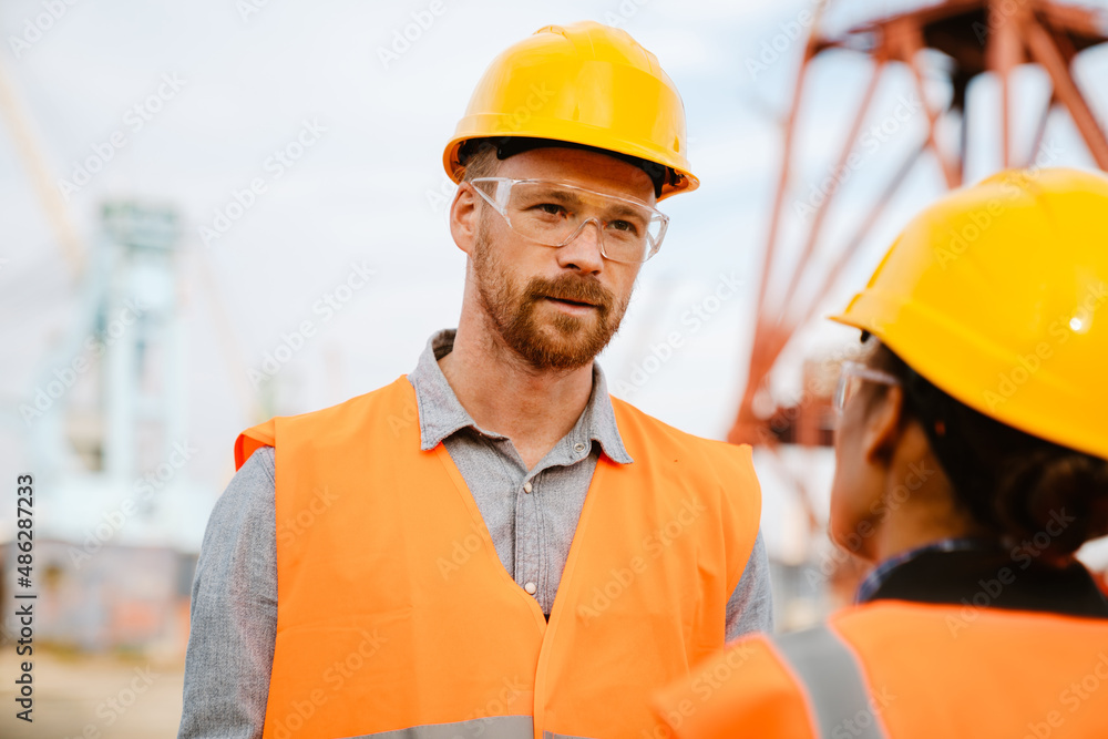 Multiracial man and woman talking while working at port Multiracial man and woman talking while working at port