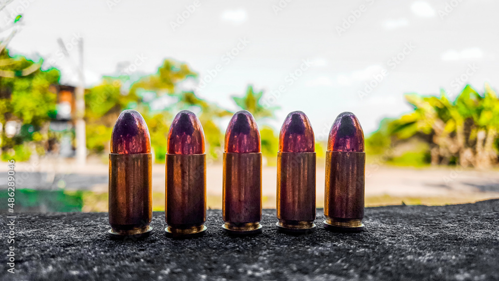 Bronze shiny bullets on dark gray fabric. Concept for security of social, personal and shooting sport equipment Bronze shiny bullets on dark gray fabric. Concept for security of social, personal and shooting sport equipment