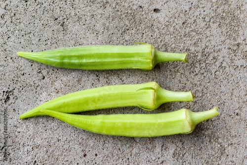 fresh green okra on cement floor photo