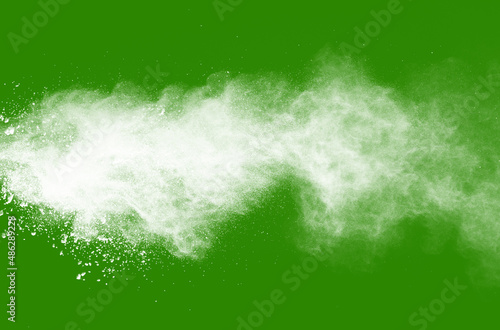 Explosion of white powder isolated on green background. Abstract colored background. holi festival.