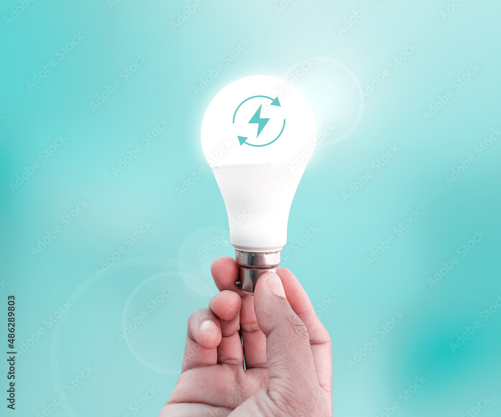 Renewable Energy Concept Abstract Background with Glowing Bulb in the Hand. Energy Renewable Icon inside the glowing bulb Renewable Energy Concept Abstract Background with Glowing Bulb in the Hand. Energy Renewable Icon inside the glowing bulb