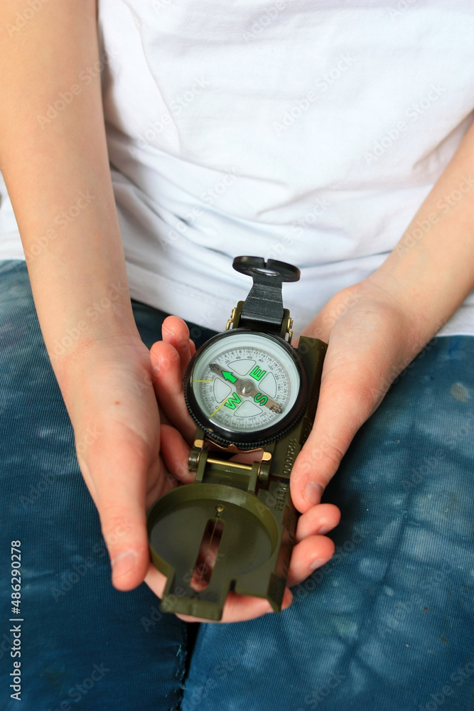 Child holding a tourist compass Child holding a tourist compass