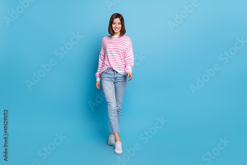Photo of adorable sweet lady dressed pink pullover walking smiling isolated blue color background
