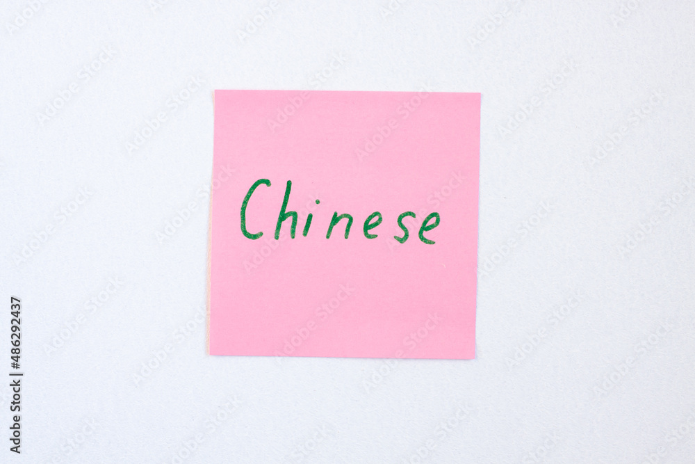 Top view flat lay of the reminder notepaper of pink color with word Chinese on it on white background. Flashcards and language studies concept Top view flat lay of the reminder notepaper of pink color with word Chinese on it on white background. Flashcards and language studies concept