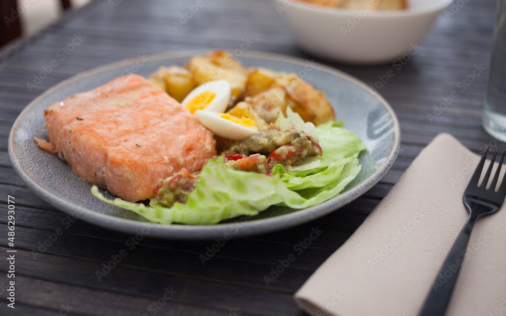 steamed salmon fillet with potato wedges, guacamole homemade and quail egg