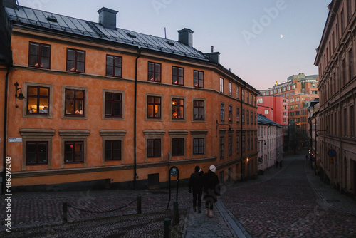 Couple walking down a Swedish cobblestone street in Sodermalm at Christmas, south Stockholm, Sweden.
