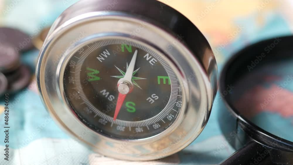 top view of holding a compus with travel map on table,