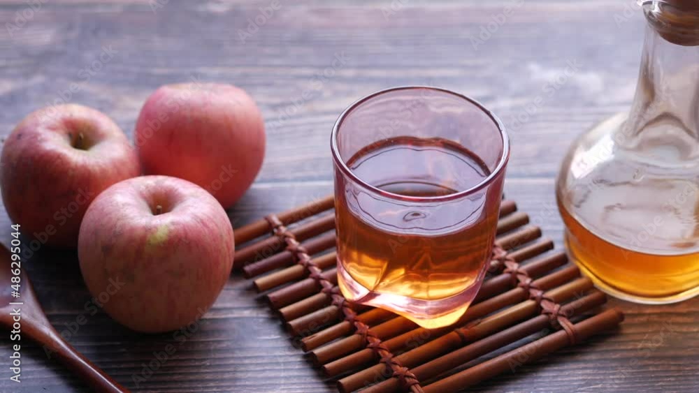 apple vinegar in glass bottle with fresh green apple on table apple vinegar in glass bottle with fresh green apple on table