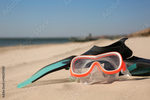Pair of flippers and diving mask on sandy beach © New Africa