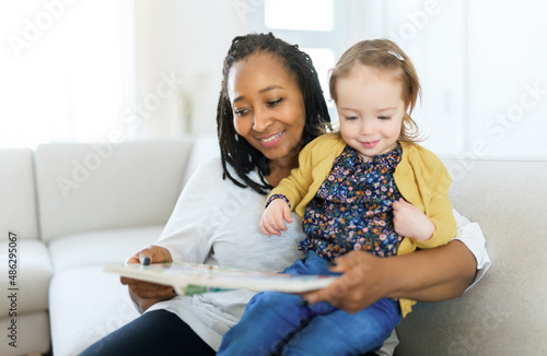 babysitter black woman read book with little child girl