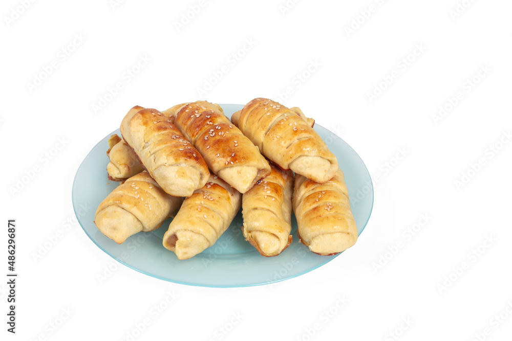Croissants with sesame seeds on a blue plate are baked by yourself. Baking isolate on a white background