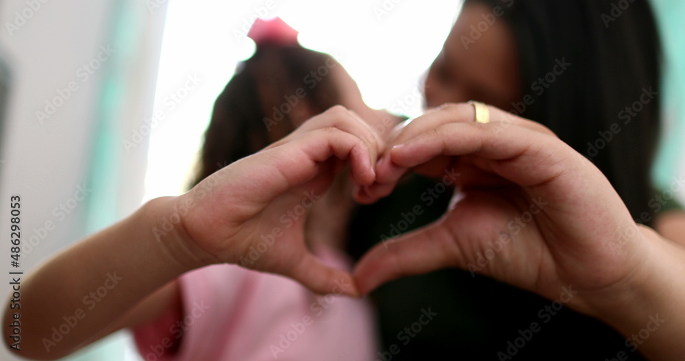 Fototapeta premium Mother and child doing heart symbol sign with hands