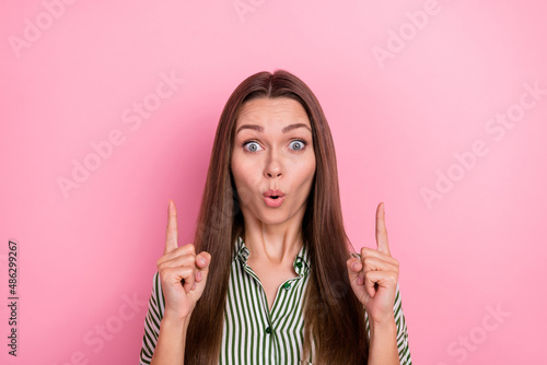 Photo of surprised lovely funky lady direct fingers empty space wear striped green shirt isolated pink color background