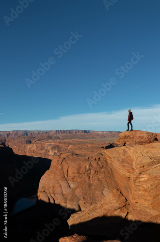 Young man hiking in arid Arizona with blue sky in the background