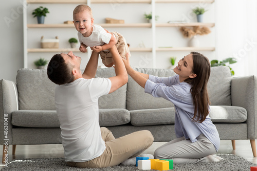 Young Parents Having Fun With Their Adorable Toddler Son At Home photo