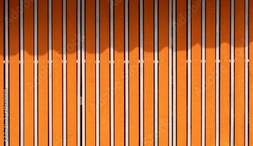 Background of vintage sliding gate made of wood and stainless steel with sunlight and shadow on surface
