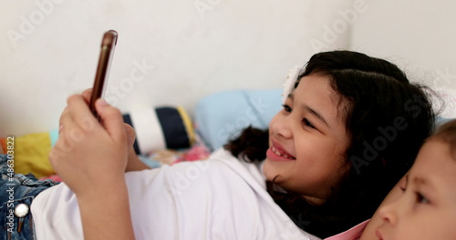 Female children siblings using cellphone