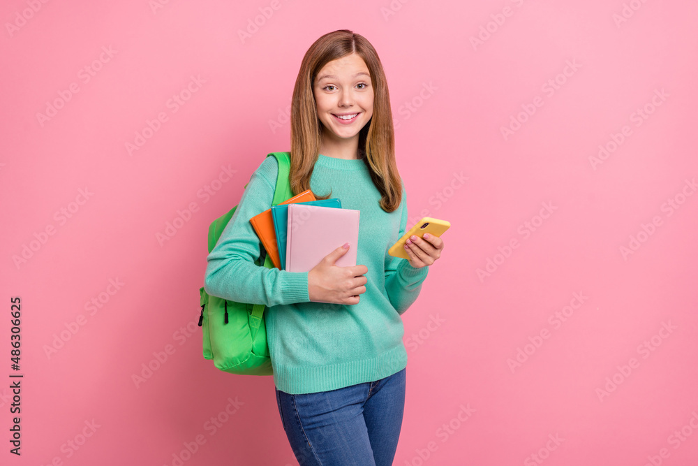 Photo of pretty cute girl wear turquoise sweater holding school supplies modern device isolated pink color background Photo of pretty cute girl wear turquoise sweater holding school supplies modern device isolated pink color background