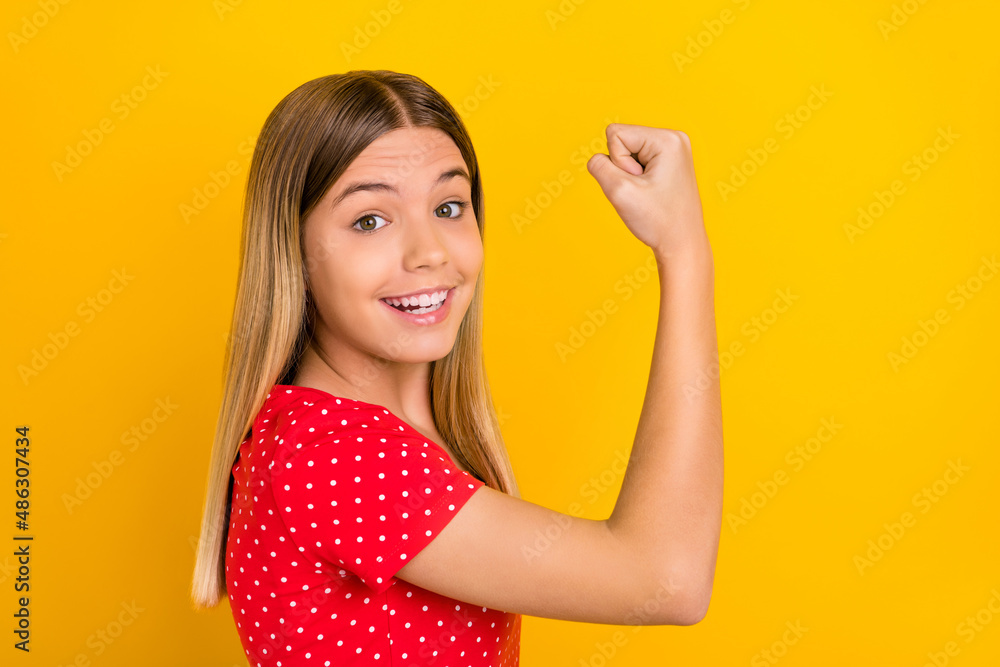 Profile side photo of young girl rejoice success triumph fist hands sporty strong isolated over yellow color background Profile side photo of young girl rejoice success triumph fist hands sporty strong isolated over yellow color background