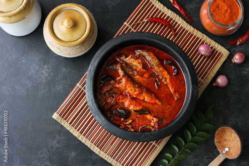 Top view of Sardine fish curry hot spicy Kerala masala fish curry for rice India Indian food red chili curry leaf Asian cuisine. Bengali Goan red fish curry coconut milk, mango clay pot Sri Lanka