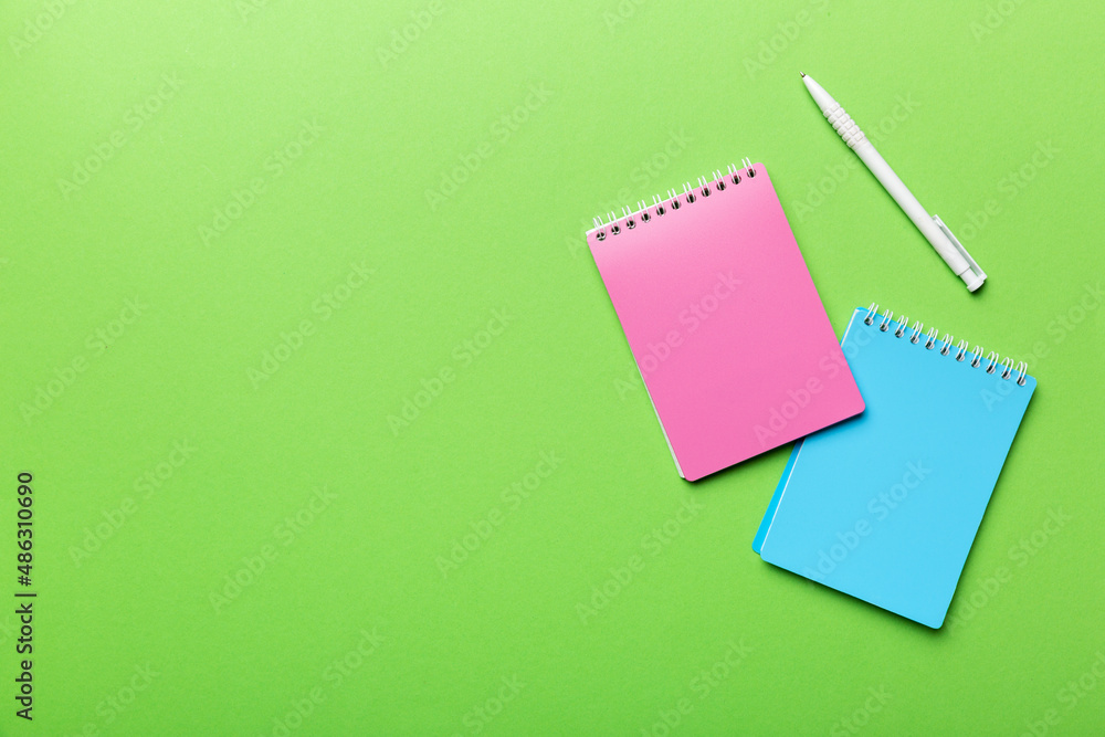 two school colored notebook on a desk background, spiral craft notepad on a table Top view two school colored notebook on a desk background, spiral craft notepad on a table Top view