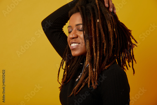 Studio shot of woman with dreadlocks against yellow background photo
