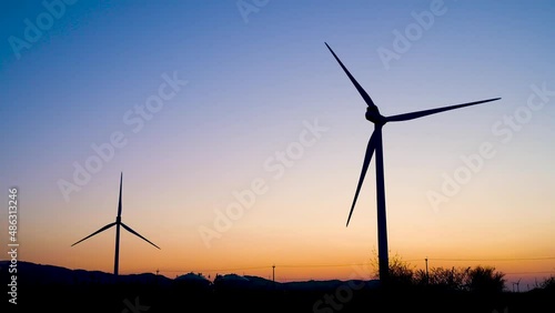 夕暮れの響灘埋立地に回る風力発電機　4kビデオ
