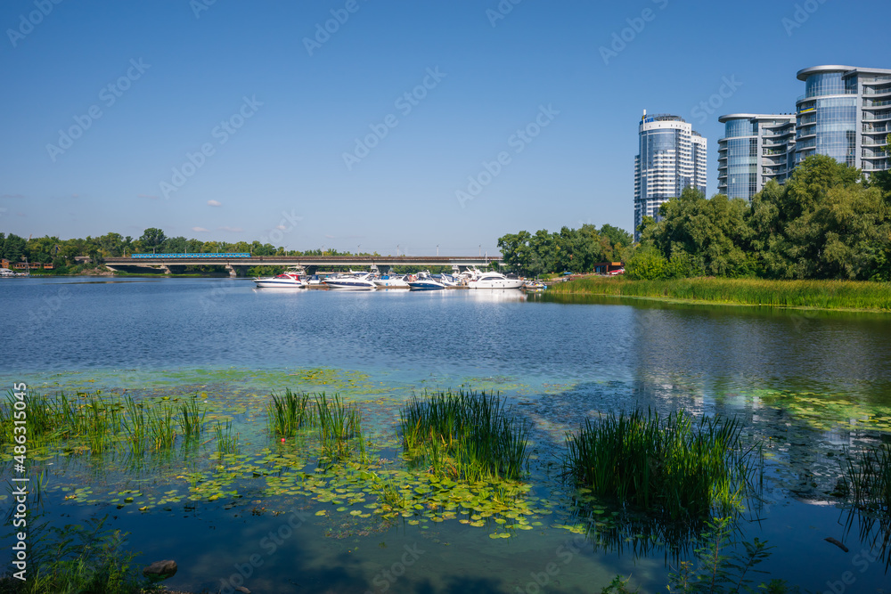 Urban landscape, fusion of nature and urbanism. Beautiful cityscape with river, yacht bridge and skyscrapers
