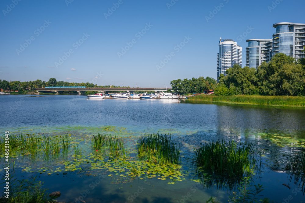 Urban landscape, fusion of nature and urbanism. Beautiful cityscape with river, yacht bridge and skyscrapers Urban landscape, fusion of nature and urbanism. Beautiful cityscape with river, yacht bridge and skyscrapers