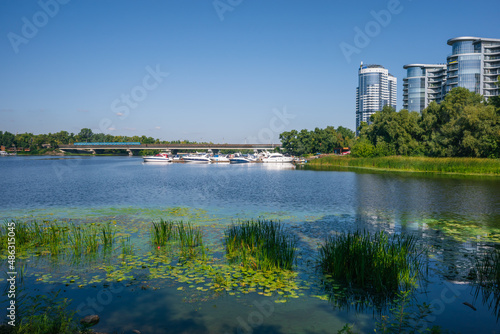 Urban landscape, fusion of nature and urbanism. Beautiful cityscape with river, yacht bridge and skyscrapers