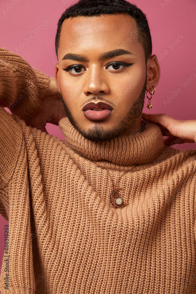 Studio portrait of queer man against purple background Studio portrait of queer man against purple background