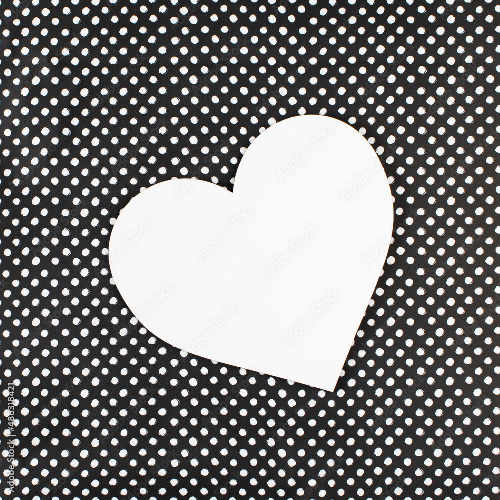 White heart on a black background with white dots. Minimal concept of love and empty space.