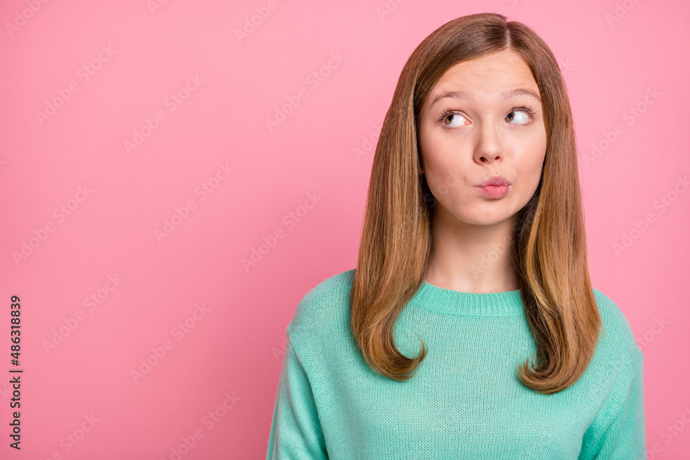 Fototapeta premium Photo of doubtful school girl dressed teal pullover looking empty space isolated pink color background