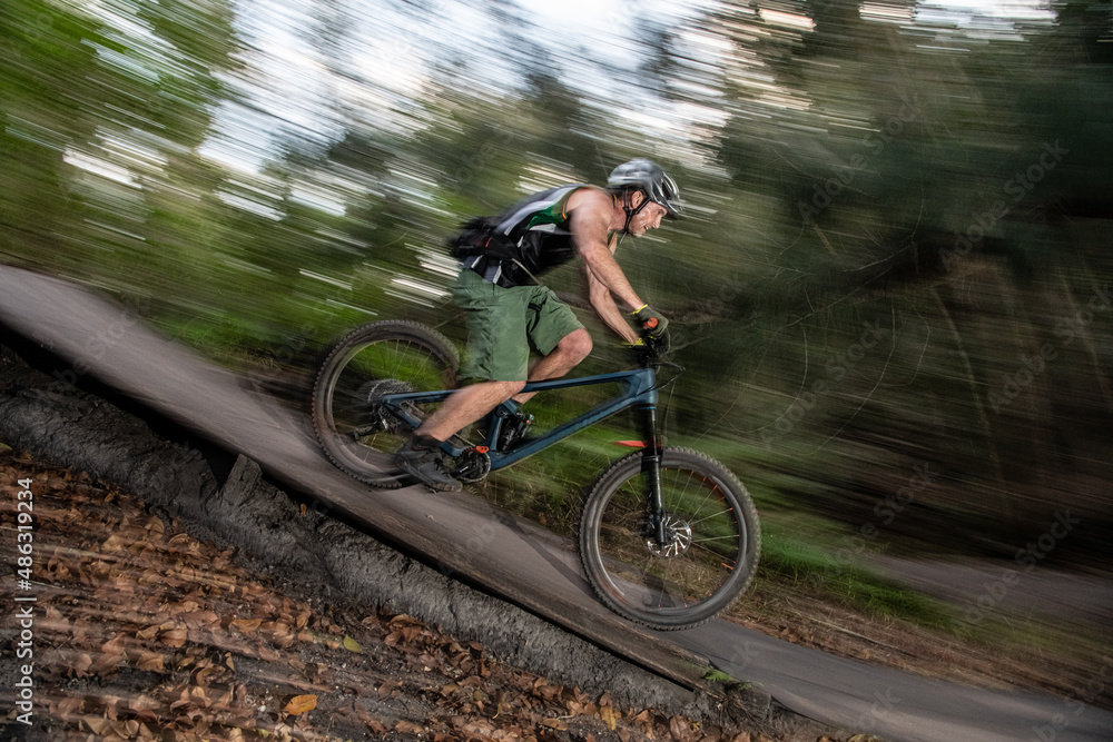 man going down hill on mountain bike
