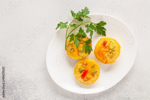 Egg muffins ( bites) and parsley leaves  in a plate on a gray background. Top view