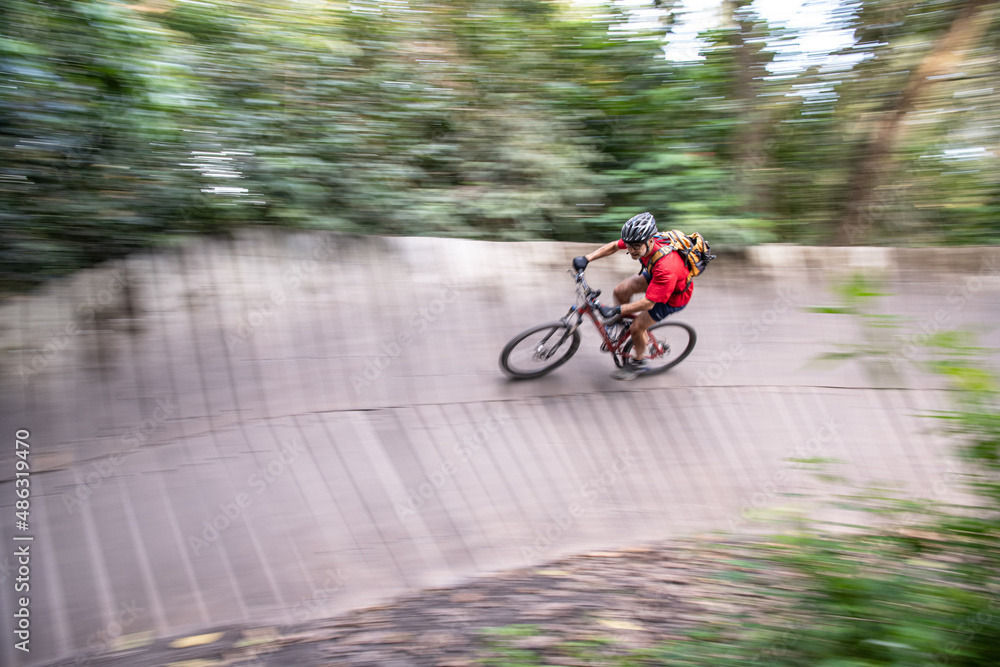 Man mountain biking turning on a wooden trail