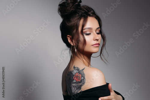 Pretty girl with sexy figure, long brown glancy hair posing at studio.