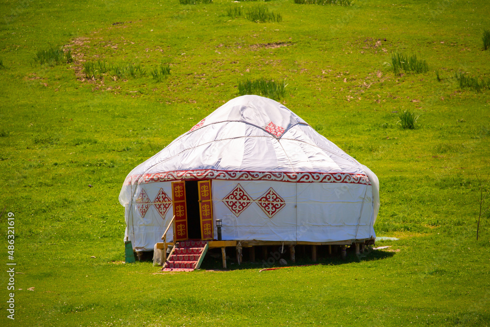 Yurt. National ancient house of the peoples of Kazakhstan and Asian countries. National Housing. Yurts on the background of a green meadow and highlands.