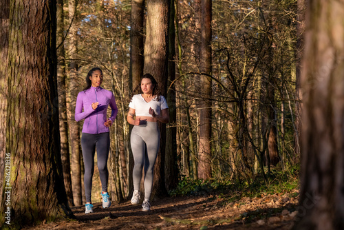 Young women jogging in forest © Cultura Creative