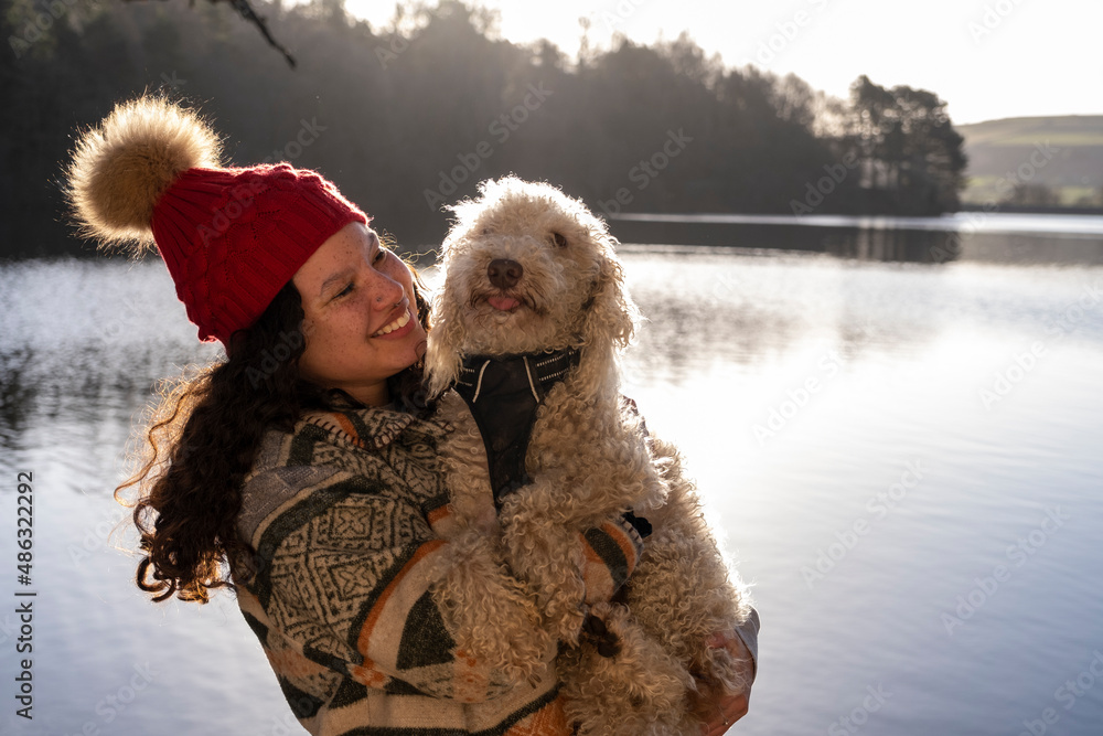 Young woman holding dog at lake Young woman holding dog at lake