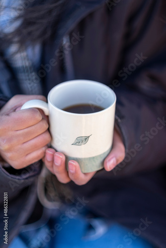 Woman holding mug with hot drink