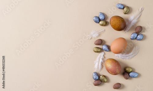 Natural Easter eggs with small candies of dragees. Easter eggs on a beige background with dragees copy space.