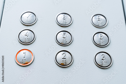 A close shot of burning elevator buttons. First floor. Call the elevator cabin. Minimalistic design of buttons