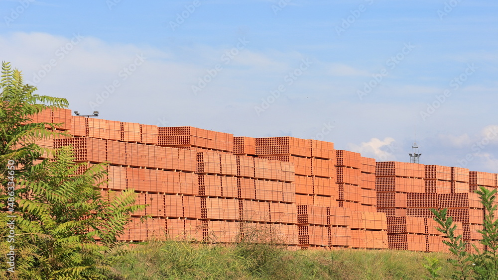 Fototapeta premium Tavelloni di colore rosso, laterizi accatastati all 'aria aperta. Materiali per edilizia.