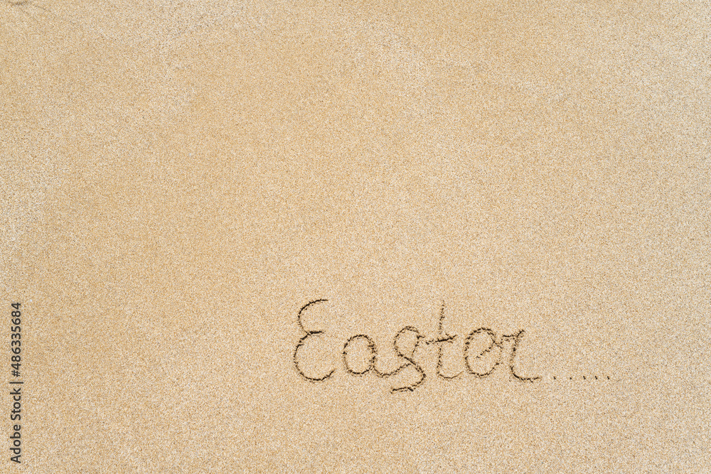 Drawing easter word on the sand on the beach. Drawing easter word on the sand on the beach.