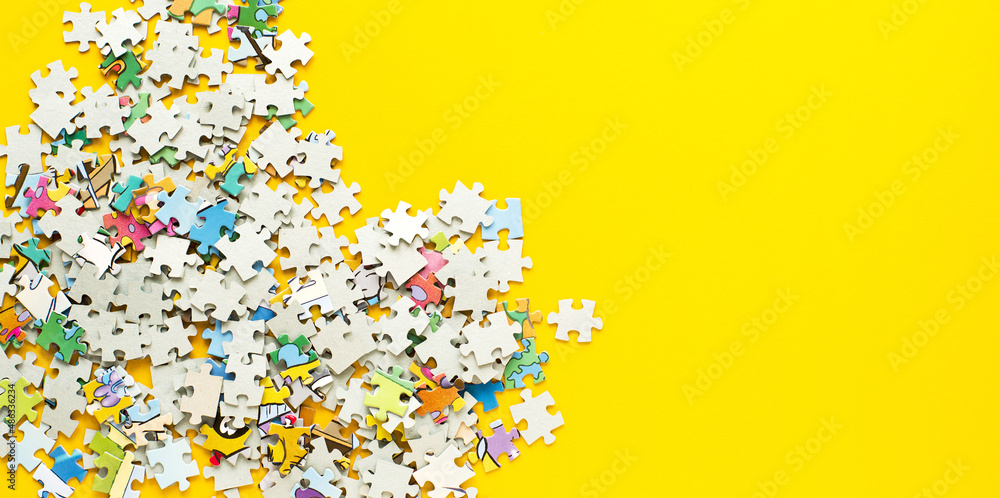 Scattered puzzles on bright yellow background, banner, top view, copy space. Board games, hobby, leisure