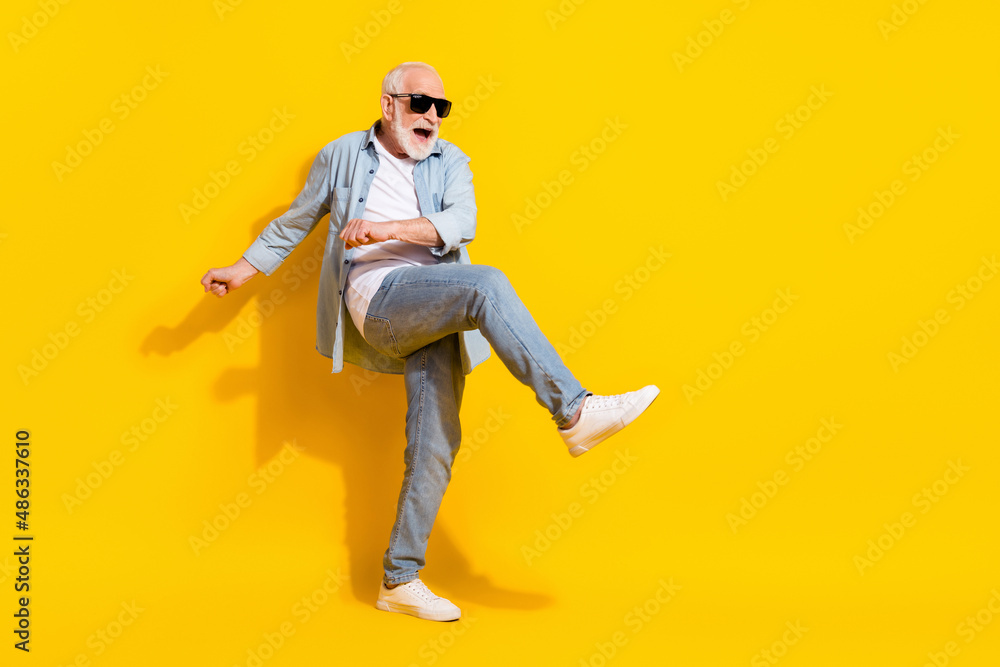 Full length body size view of attractive cheerful crazy grey-haired man dancing having fun isolated over bright yellow color background Full length body size view of attractive cheerful crazy grey-haired man dancing having fun isolated over bright yellow color background