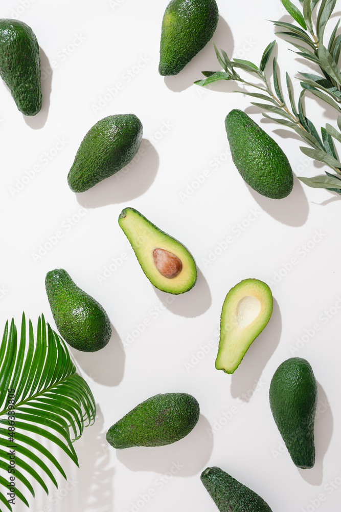Whole ripe eco avocados on a white background. High key. Avocado slices top view. Whole ripe eco avocados on a white background. High key. Avocado slices top view.